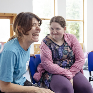 A Travelling Light facilitator laughing with a participant. Photo by Camilla Adams.
